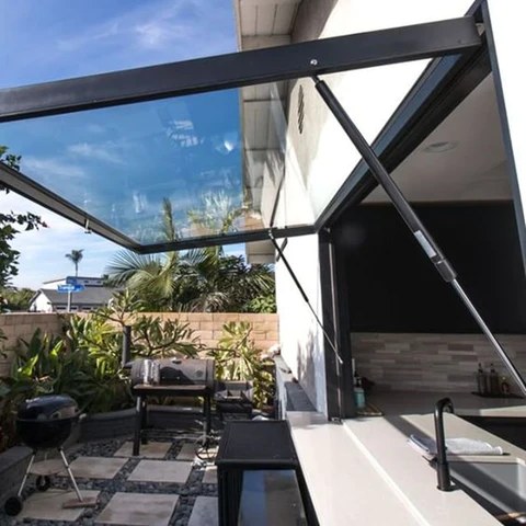 Electric fold-up pass-through window opened above an outdoor kitchen counter